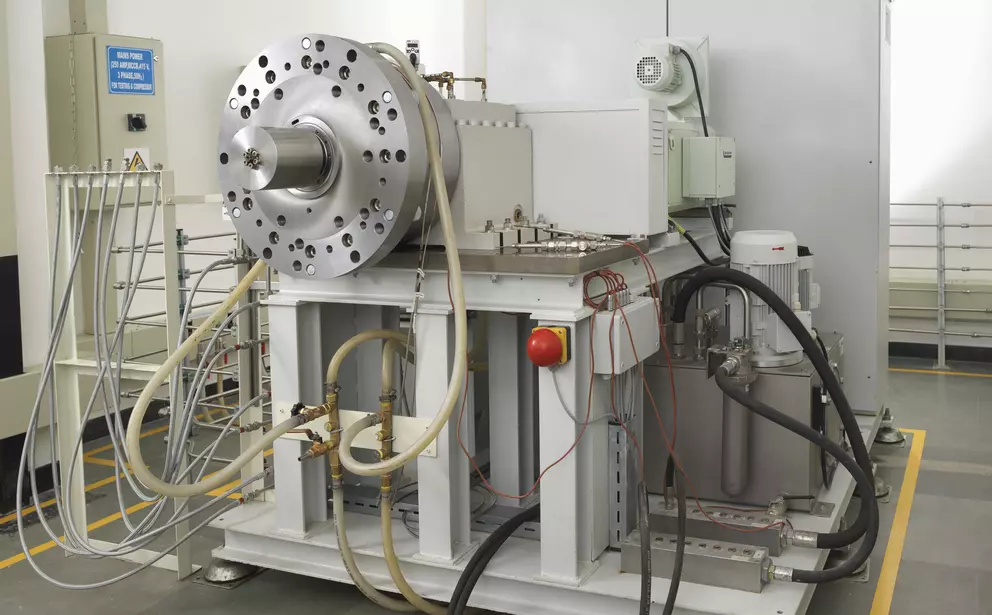Industrieller Prüfstand für Gleitringdichtungen oder Rotorkomponenten mit Hydraulikleitungen, Messinstrumenten und robustem Testgehäuse.