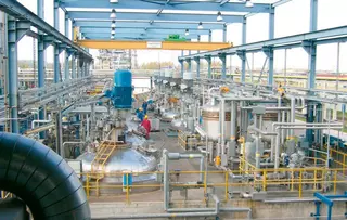 Large-scale process plant with vessels, piping, and maintenance area.