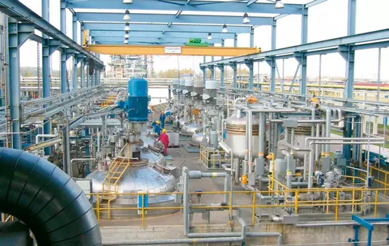 Large-scale process plant with vessels, piping, and maintenance area.