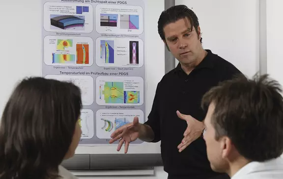 Ingenieur präsentiert technische Analysen und Diagramme – Mitarbeiterschulung zu Prozessoptimierung, Simulation und industrieller Dichtungstechnik.