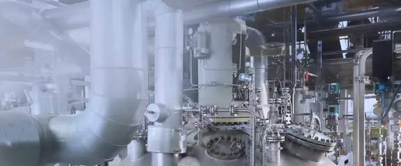 Industrial process plant with piping, vessels, and valves in a modern production environment.