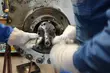 Hands installing or servicing an industrial mechanical seal inside machinery, showing precision maintenance work with protective gloves and technical tools.